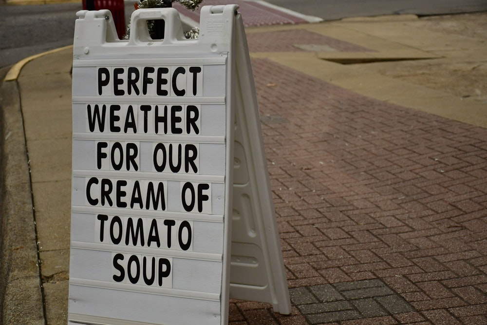 perfect weather for our cream of tomato soup text on brown brick pavement